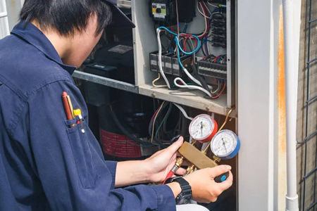 Technician performing spring AC tune-up for a Westchester County home