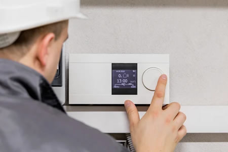 Technician calibrating a smart thermostat in a Westchester County home